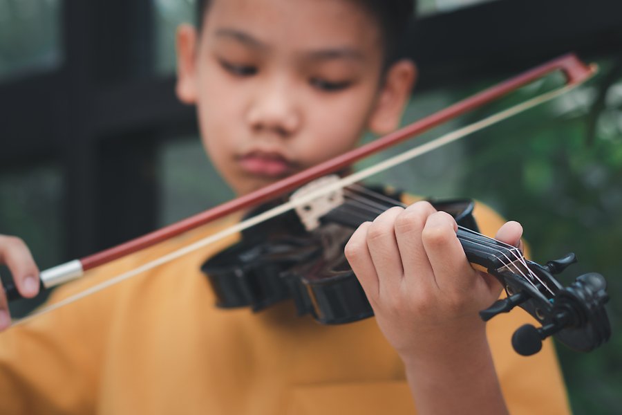 En pojke spelar fiol.
